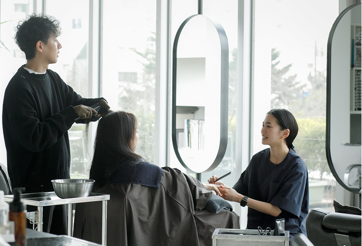 シャンプーとネイルを同時に施術している様子